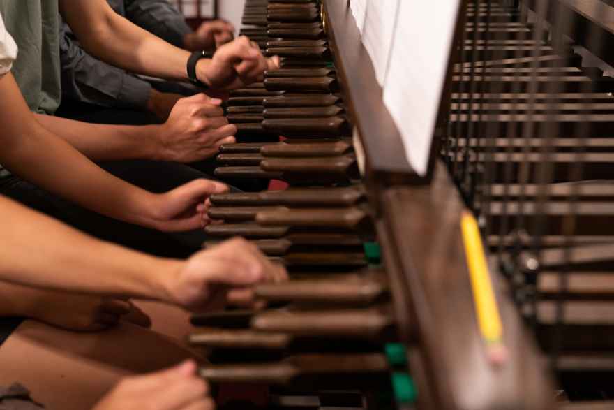 Eight hands and two feet are required for the introduction to "Crescat scientia, vita excolutur," Prof. Augusta Read Thomas's carillon composition for President Paul Alivisatos's inauguration. The final chord requires the combined efforts of 12 carillonneurs, an additional four people not pictured. Photo by Jason Smith