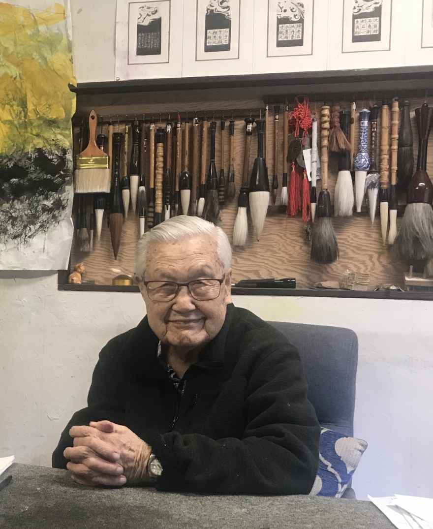 Hou Beiren with his extensive collection of paint brushes for his artwork