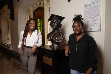 Third-year students Marla Anderson (right) and Dayo Adeoye pose with the bust of Georgiana Simpson in the Reynolds Club at the University of Chicago. Anderson and Adeoye created the Georgiana Simpson Organization last year to honor Simpson's pioneering legacy and foster the advancement of Black women at UChicago.