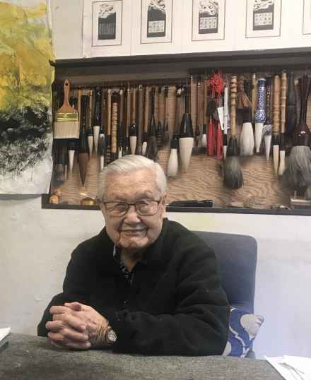 Hou Beiren with his extensive collection of paint brushes for his artwork