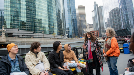 UChicago scholars Amber Ginsburg (right) and Jennifer Scappettone (second from right) discuss the history of the Chicago River during a class trip on a water taxi. Photo by Jean Lachat